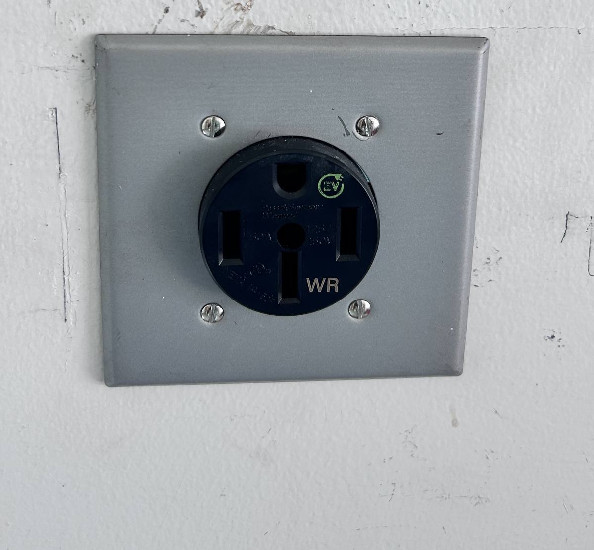 NEMA 14-50 receptacle rated for EV charging with weather resistant marking on a metal plate